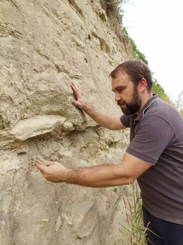 Luca Roagna looking at soil in a vineyard